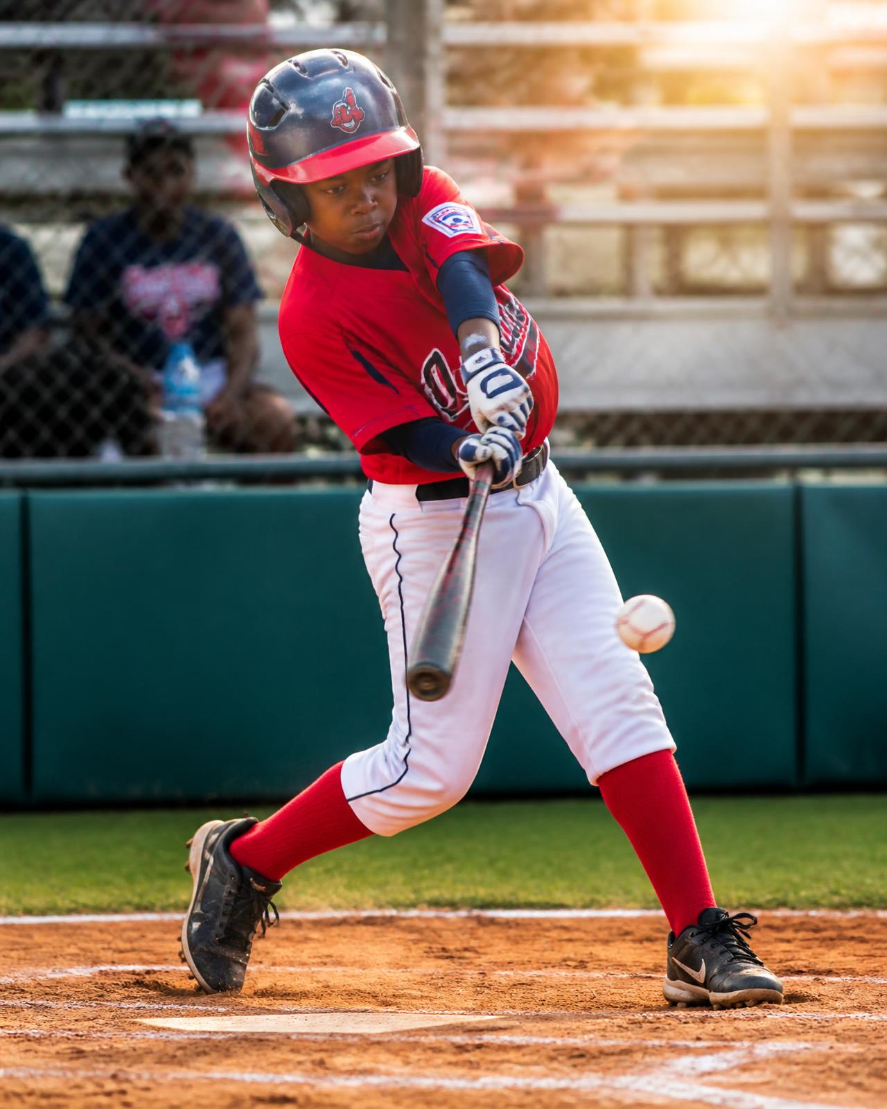 Young baseball player connecting with a pitch